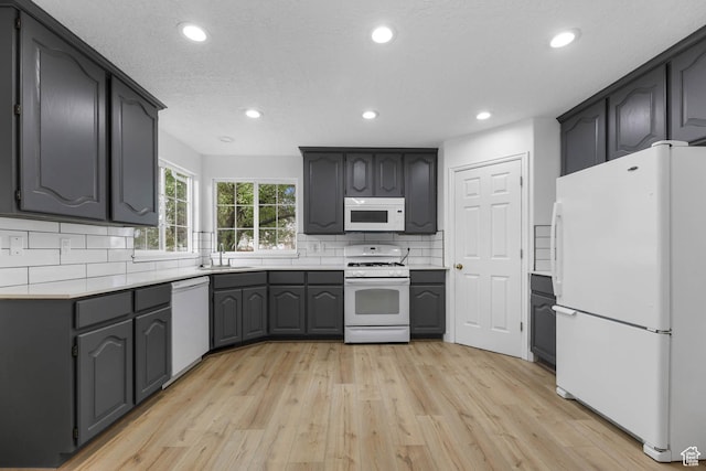 9448 S Lady Dove Ln, South Jordan, UT 84095 - kitchen featuring white appliances, light wood-style floors, recessed lighting, tasteful backsplash, and light countertops