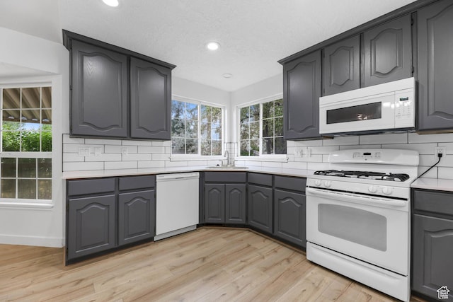 9448 S Lady Dove Ln, South Jordan, UT 84095 - kitchen with white appliances, light wood finished floors, decorative backsplash, recessed lighting, and light countertops