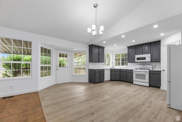 9448 S Lady Dove Ln, South Jordan, UT 84095 - kitchen with white appliances, a chandelier, backsplash, lofted ceiling, and recessed lighting