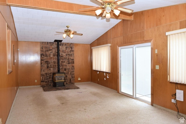 519 Edgehill Pl, East Carbon, UT 84520 - unfurnished living room with a ceiling fan, a wood stove, vaulted ceiling, wooden walls, and carpet floors