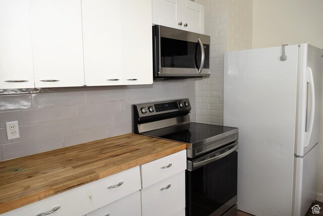 519 Edgehill Pl, East Carbon, UT 84520 - kitchen featuring appliances with stainless steel finishes, wood counters, decorative backsplash, and white cabinetry