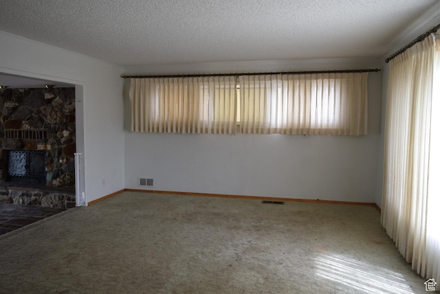 519 Edgehill Pl, East Carbon, UT 84520 - unfurnished living room featuring light colored carpet, a fireplace, and a textured ceiling