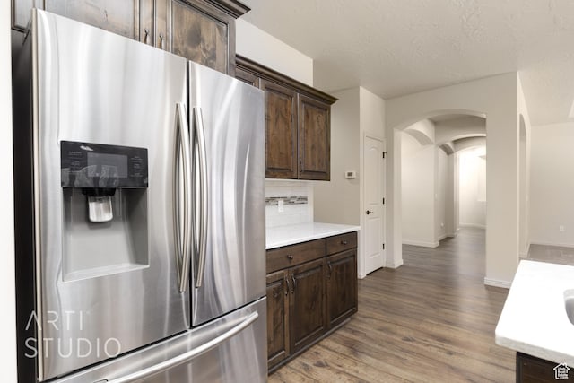 2866 E Carmine Dr, St George, UT 84790 - kitchen featuring stainless steel fridge with ice dispenser, arched walkways, dark brown cabinets, and light countertops