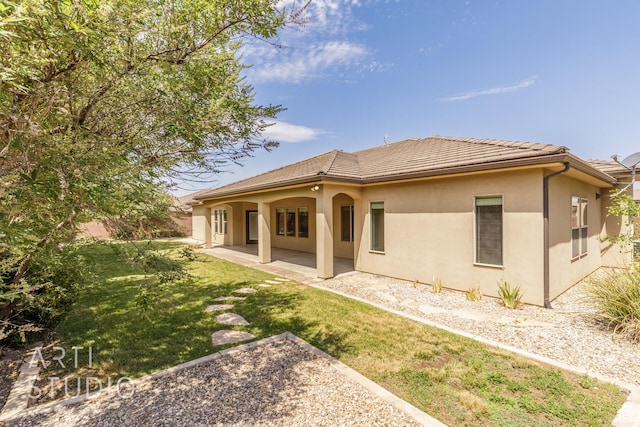 2866 E Carmine Dr, St George, UT 84790 - back of property featuring stucco siding, a lawn, a patio area, and a tiled roof