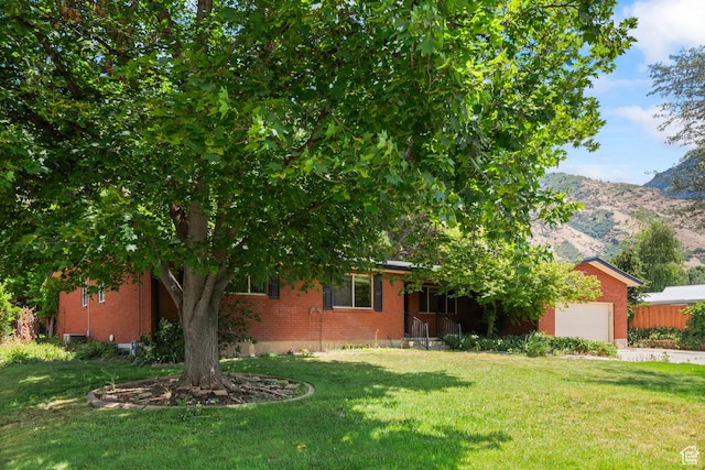 3020 Cherokee Ln, Provo, UT 84604 - obstructed view of property with an attached garage, a front yard, brick siding, a mountain view, and concrete driveway