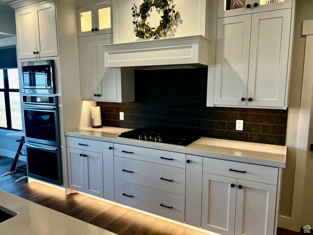 2346 Lake Cir, Preston, ID 83263 - kitchen with black appliances, light countertops, dark wood finished floors, glass insert cabinets, and backsplash