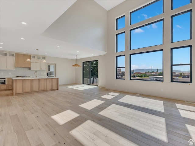 1395 N 330 E Unit 3, Orem, UT 84057 - unfurnished living room with light wood finished floors, recessed lighting, and a towering ceiling