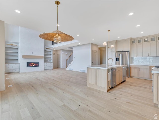 1395 N 330 E Unit 3, Orem, UT 84057 - kitchen with light countertops, light wood-style flooring, stainless steel appliances, a large fireplace, and recessed lighting
