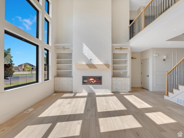 1395 N 330 E Unit 3, Orem, UT 84057 - unfurnished living room with a high ceiling, a large fireplace, wood finished floors, stairway, and built in features