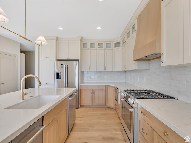 1395 N 330 E Unit 3, Orem, UT 84057 - kitchen with stainless steel appliances, premium range hood, light wood-type flooring, light stone countertops, and glass insert cabinets