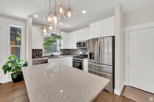 10376 S Beetdigger Blvd, Sandy, UT 84070 - kitchen featuring stainless steel appliances, decorative backsplash, light stone countertops, white cabinets, and wood finished floors