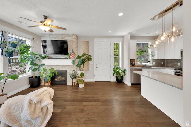 10376 S Beetdigger Blvd, Sandy, UT 84070 - living area featuring a ceiling fan, a fireplace, dark wood finished floors, recessed lighting, and a textured ceiling