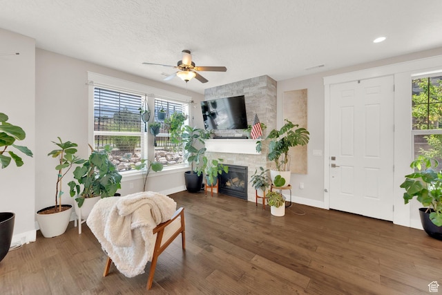10376 S Beetdigger Blvd, Sandy, UT 84070 - living area with a fireplace, ceiling fan, healthy amount of natural light, wood finished floors, and a textured ceiling