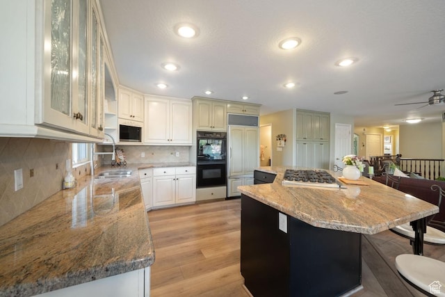 10025 Silver Streak Dr, South Jordan, UT 84095 - kitchen with built in appliances, light stone countertops, backsplash, a kitchen island, and a breakfast bar area