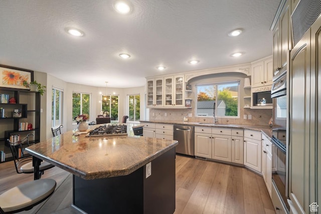 10025 Silver Streak Dr, South Jordan, UT 84095 - kitchen featuring stainless steel appliances, open shelves, a center island, a kitchen breakfast bar, and plenty of natural light
