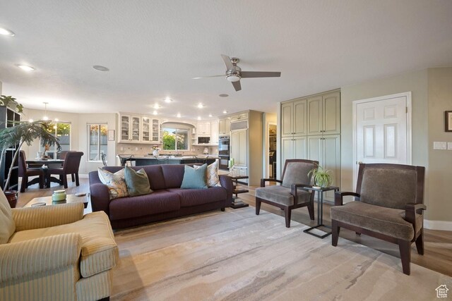 10025 Silver Streak Dr, South Jordan, UT 84095 - living room featuring light wood-type flooring, a ceiling fan, a chandelier, and recessed lighting