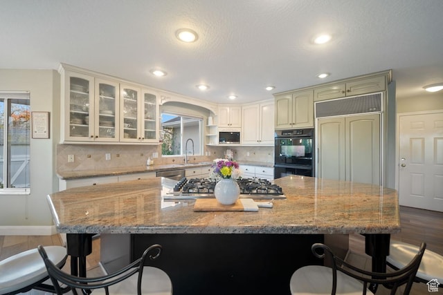 10025 Silver Streak Dr, South Jordan, UT 84095 - kitchen with built in appliances, a breakfast bar, wood finished floors, backsplash, and recessed lighting