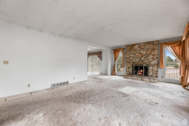 8614 S Buena Vista Dr E, Sandy, UT 84094 - unfurnished living room featuring a textured ceiling, healthy amount of natural light, carpet flooring, and a fireplace