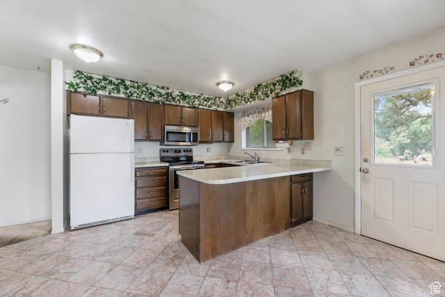 8614 S Buena Vista Dr E, Sandy, UT 84094 - kitchen featuring stainless steel appliances, a peninsula, light countertops, and dark brown cabinetry