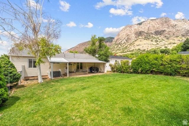1121 Southwell St, Ogden, UT 84404 - back of house with a lawn, a mountain view, and a patio