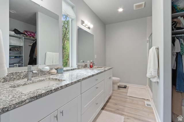 1288 Lincoln Ave, Ogden, UT 84404 - full bath with double vanity, a walk in closet, wood finished floors, and plenty of natural light