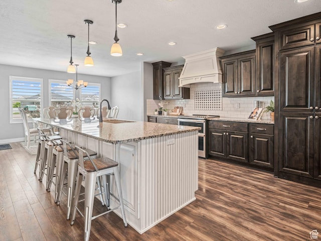 3552 S 5250 W Unit 13, Hooper, UT 84315 - kitchen with range with two ovens, custom range hood, dark wood finished floors, backsplash, and light stone counters
