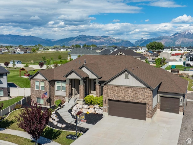 3552 S 5250 W Unit 13, Hooper, UT 84315 - view of front of house featuring brick siding, a mountain view, concrete driveway, a garage, and a residential view