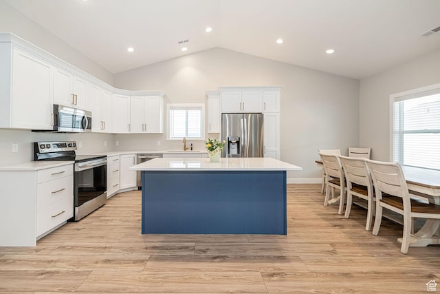 318 E 290 N, Preston, ID 83263 - kitchen featuring stainless steel appliances, a kitchen island, light countertops, white cabinetry, and vaulted ceiling