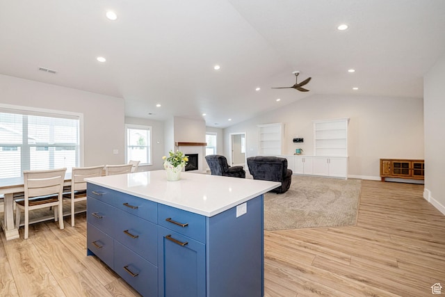 318 E 290 N, Preston, ID 83263 - kitchen featuring a center island, a ceiling fan, light wood-style floors, blue cabinetry, and lofted ceiling