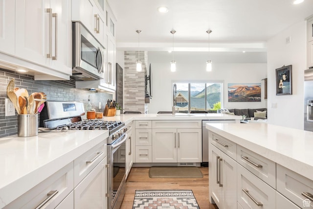 538 W Heritage Way, Heber City, UT 84032 - kitchen with appliances with stainless steel finishes, decorative backsplash, light countertops, light wood-type flooring, and white cabinetry