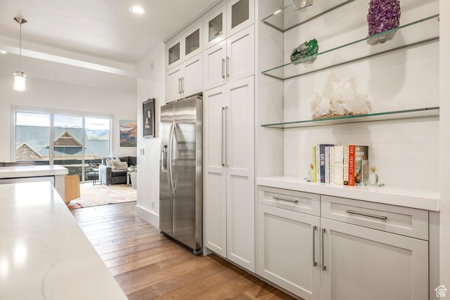 538 W Heritage Way, Heber City, UT 84032 - kitchen featuring stainless steel fridge, light countertops, light wood-style flooring, recessed lighting, and glass insert cabinets