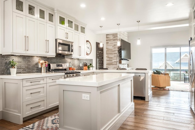 538 W Heritage Way, Heber City, UT 84032 - kitchen featuring appliances with stainless steel finishes, backsplash, light countertops, a peninsula, and hardwood / wood-style flooring