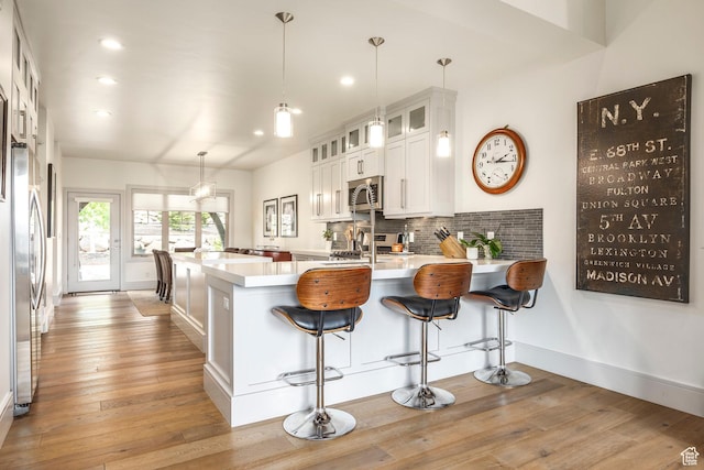 538 W Heritage Way, Heber City, UT 84032 - kitchen with appliances with stainless steel finishes, a peninsula, light wood finished floors, light countertops, and recessed lighting