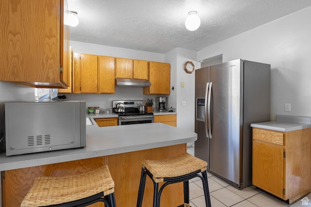 6446 S 4160 W, Taylorsville, UT 84129 - kitchen featuring appliances with stainless steel finishes, under cabinet range hood, light countertops, a peninsula, and a textured ceiling