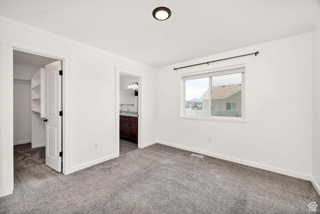 496 S 1600 E, Hyrum, UT 84319 - unfurnished bedroom featuring carpet, a walk in closet, connected bathroom, and a closet