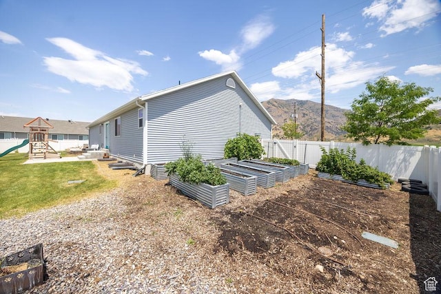 496 S 1600 E, Hyrum, UT 84319 - view of home's exterior featuring a garden, a playground, a fenced backyard, and a mountain view