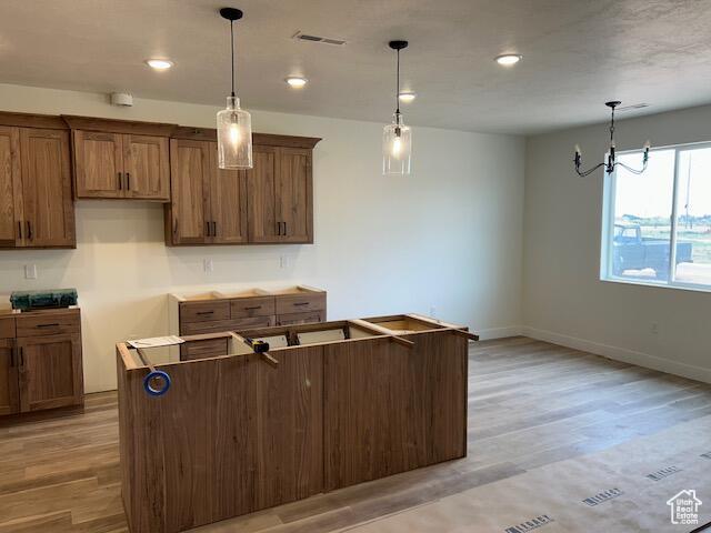 1966 W 4750 N Unit 7, Enoch, UT 84721 - kitchen with hanging light fixtures, light wood-style floors, a chandelier, brown cabinets, and recessed lighting