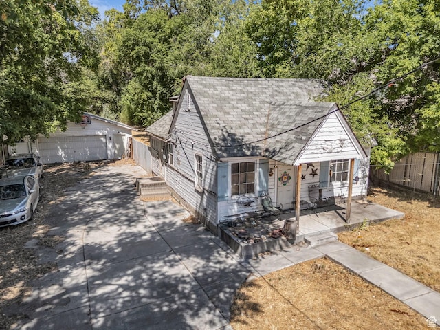 4104 S 300 E, Millcreek, UT 84107 - view of front of home with a shingled roof, an outbuilding, covered porch, and a detached garage