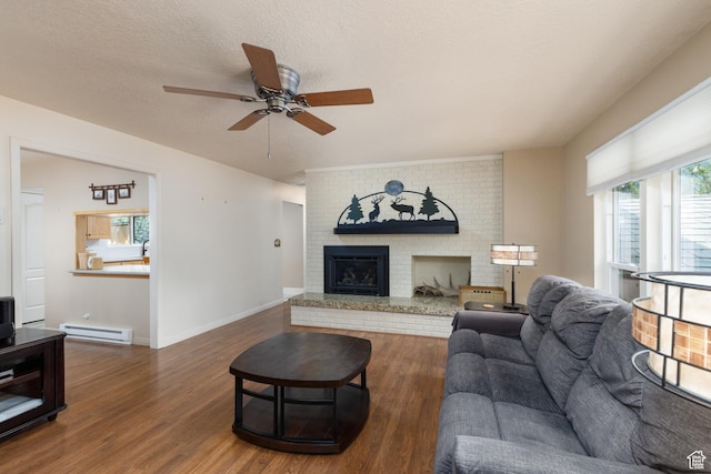 3250 N River Dr, Eden, UT 84310 - living area featuring baseboard heating, a ceiling fan, dark wood-type flooring, and a fireplace