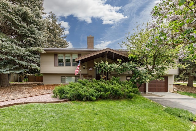 3250 N River Dr, Eden, UT 84310 - view of front of house featuring concrete driveway, a chimney, a front lawn, and a garage