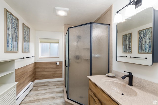 3250 N River Dr, Eden, UT 84310 - bathroom with baseboard heating, vanity, a stall shower, and wood finished floors