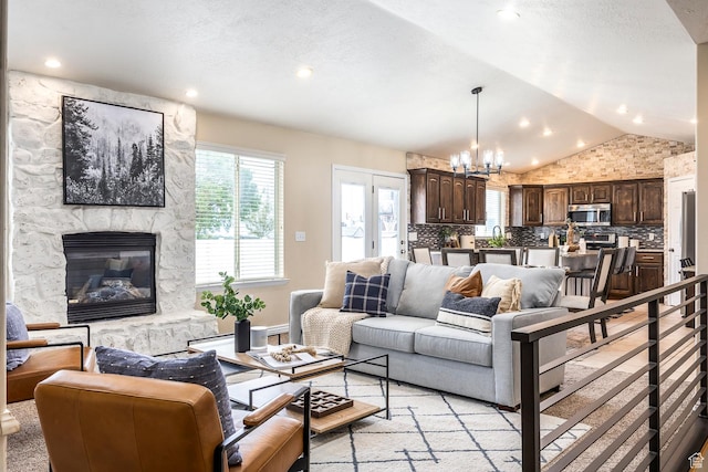 9768 N 5520 W, Highland, UT 84003 - living room with vaulted ceiling, plenty of natural light, a chandelier, a fireplace, and recessed lighting