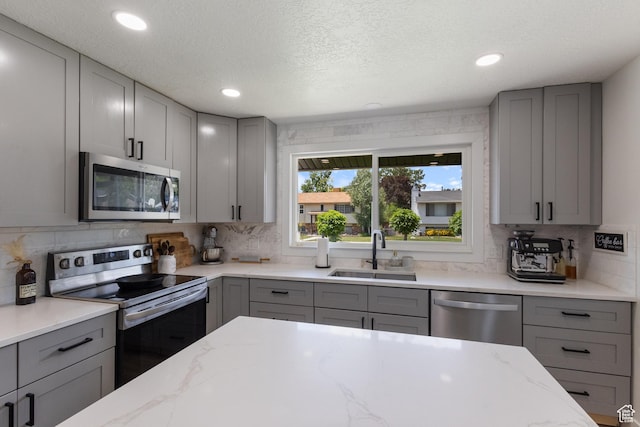 9499 S 220 E, Sandy, UT 84070 - kitchen featuring gray cabinets, stainless steel appliances, backsplash, recessed lighting, and a textured ceiling