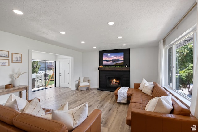 9499 S 220 E, Sandy, UT 84070 - living area with a textured ceiling, light wood finished floors, recessed lighting, and a fireplace