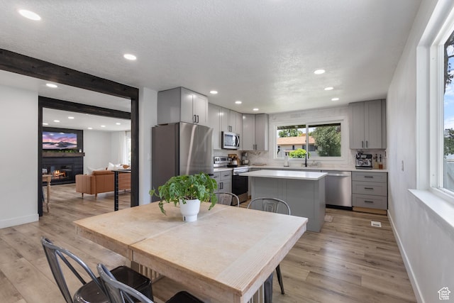 9499 S 220 E, Sandy, UT 84070 - dining area with recessed lighting, a glass covered fireplace, light wood-style floors, and a textured ceiling