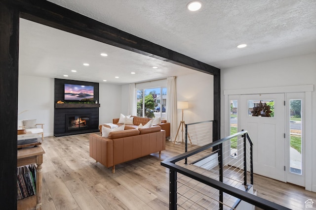9499 S 220 E, Sandy, UT 84070 - living area featuring light wood-type flooring, beamed ceiling, a textured ceiling, a large fireplace, and recessed lighting