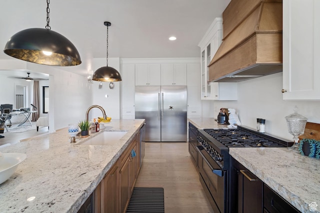 3317 S Watchman Trl, Moab, UT 84532 - kitchen featuring custom exhaust hood, high end appliances, glass insert cabinets, light stone counters, and white cabinets