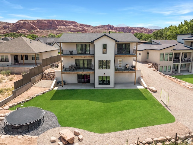 3317 S Watchman Trl, Moab, UT 84532 - rear view of property with a balcony, a patio, a mountain view, a fenced backyard, and stucco siding
