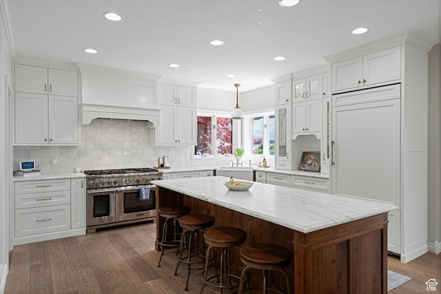 5040 S 1450 E, Ogden, UT 84403 - kitchen featuring range with two ovens, wood finished floors, white cabinets, backsplash, and recessed lighting