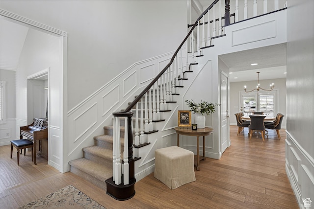 5040 S 1450 E, Ogden, UT 84403 - stairs with a decorative wall, wood finished floors, a chandelier, a high ceiling, and a wainscoted wall